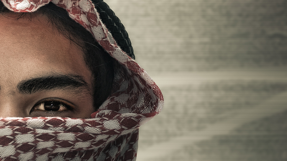 A man partially covered by a keffiyeh, evoking themes of identity, conflict, and radicalization.