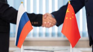 Political flags of russia and chinese on table in international negotiation room. concept of negotiations, collaboration and cooperation of countries. agreement between the governments.