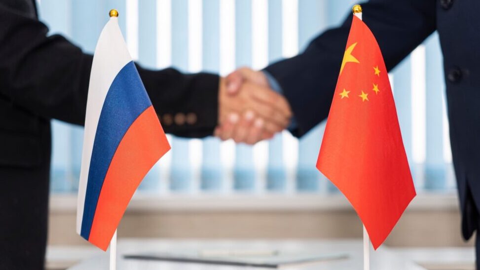 Political flags of russia and chinese on table in international negotiation room. concept of negotiations, collaboration and cooperation of countries. agreement between the governments.